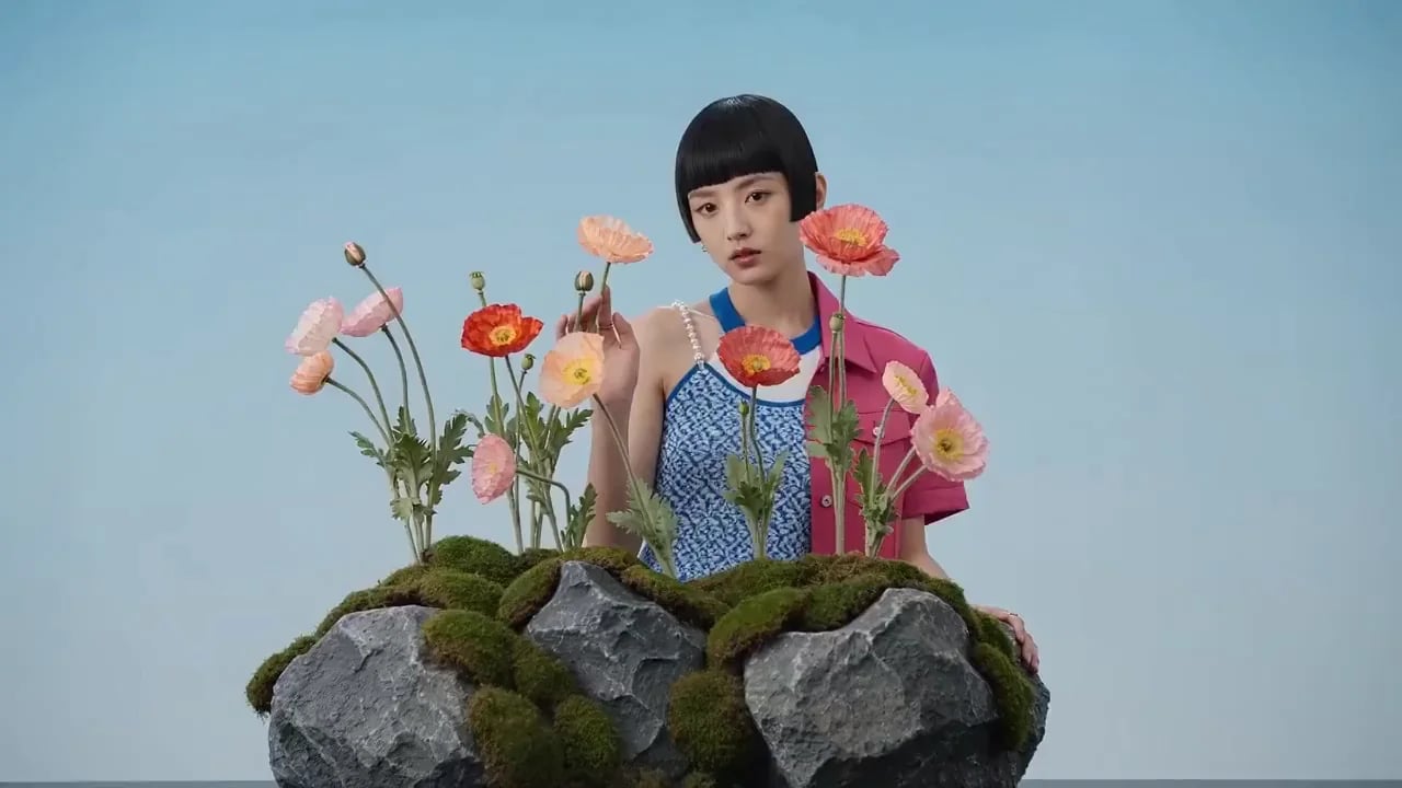 A model with a short bob poses among poppies in a jewelry campaign.