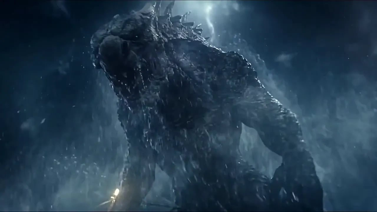 A giant sea creature rises out of a night storm beside a small fishing boat.